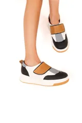 Championes urbanos de cuero vacuno color blanco, negro, gris y marrón, con ajuste mediante tira con velcro y suela de goma antideslizante.