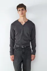 Camiseta de manga larga con cuello en V, confeccionada en tejido con efecto lavado desgastado.