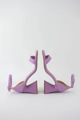 Sandalias color crema con tira delgada sobre los dedos, pulsera al tobillo con hebilla y taco geométrico.