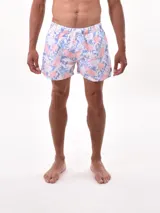 Short de baño blanco con estampado de hojas en tonos azules y rosados, cintura elástica con cordón ajustable.