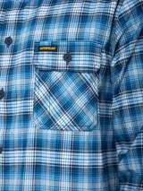 Camisa de manga larga con estampado de cuadros en tonos azules y blancos. Presenta cuello clásico, cierre frontal con botones, dos bolsillos en el pecho con solapa y puños ajustables.