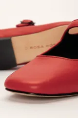 Zapato plano estilo Mary Jane de cuero negro, con punta fina y tira ajustable con hebilla sobre el empeine.