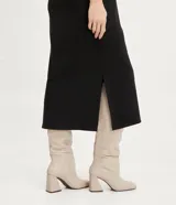 Vestido midi negro de suedine, sin mangas, con cuello alto acanalado y aberturas laterales.