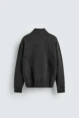 Chaqueta tipo bomber de punto compacto con efecto lavado, cuello subido, manga larga y cierre frontal con cremallera. Presenta bolsillos de vivo en la cadera y acabados en rib.