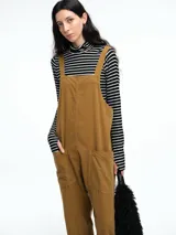 Mono largo de pana color verde oscuro, con breteles finos y silueta relajada de pierna amplia.