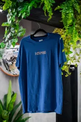 Remera azul con estampado frontal de la palabra "Hermod" en letras con efecto de fuego.