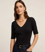 Blusa femenina de corte ajustado confeccionada en tejido rib acanalado, con escote en V y mangas cortas con dobladillo plegado.
