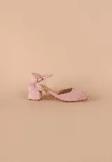 Zapato de tacón medio tipo block, color rosado, con punta cerrada redondeada y pulsera al tobillo con hebilla metálica. Presenta un acabado de textura suave.