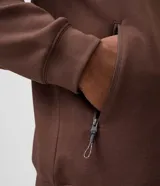Campera deportiva con capucha y cierre frontal de cremallera, confeccionada en tejido tech fleece negro con bolsillos laterales con cierre.
