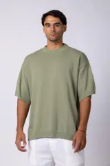 Remera de tejido de punto liviano en color verde oliva, con corte oversize, cuello redondo acanalado y mangas cortas con terminación en rib.