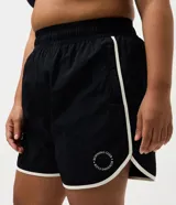 Short deportivo modelo runner de Ashua, confeccionado en poliamida con tecnología dry de secado rápido. Presenta un diseño holgado con cintura elástica, bajos redondeados con vivos laterales en contraste y detalle de lettering en el ruedo.