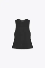 Top negro entallado de cuello redondo y sisa ancha. Cierre frontal con cremallera oculta.