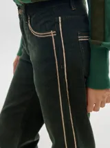 Pantalón de tiro medio confeccionado en pana color rojo, con corte holgado y detalle de línea lateral en contraste.