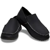 Mocasín tipo slip-on marca Crocs modelo Santa Cruz, con parte superior de lona negra y costuras visibles. Posee elásticos laterales para facilitar el calce y suela de material Croslite™ en color beige.