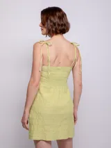 Vestido corto verde lima con textura arrugada, tirantes finos y corte recto.