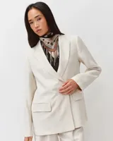 Pañuelo cuadrado de seda con flecos en los bordes y estampado bicolor en tonos beige, marrón y blanco.