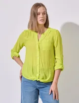 Blusa color amarillo de gasa marca Zac & Rachel, con cuello a la base, escote en V y abertura central con botones. Delantera con bolsillo aplicado. Largo de manga regulable con presilla y botón. Terminación opcional de nudo en ruedo.