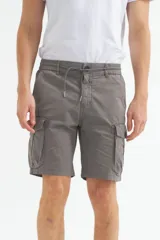 Bermuda cargo color gris oscuro, confeccionada en gabardina con efecto teñido. Presenta pretina elástica con cordón de ajuste, bolsillos laterales y bolsillos cargo con solapa en las piernas.