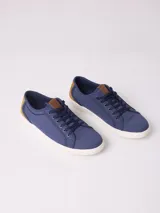 Championes de lona color beige con detalles en azul y marrón.