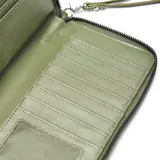 Billetera grande tipo fichero color verde oliva, confeccionada en material símil cuero con textura granulada. Cuenta con cierre perimetral, logo metálico frontal y correa de muñeca extraíble.