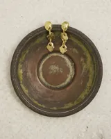 Aros colgantes de diseño orgánico con textura irregular, compuestos por tres piezas eslabonadas en acabado dorado. Incluye un earcuff a juego de diseño minimalista.