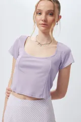 Top corto negro de escote cuadrado y manga corta con costuras tipo corsé.