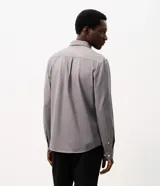 Camisa masculina Marfinno de corte slim en tono azul acero, confeccionada con cuello inglés, manga larga con puños abotonados y cierre frontal con botones. Incorpora tecnología Easy Care Performance para mayor elasticidad y facilidad de planchado.