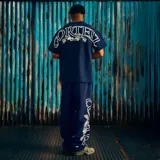 Camiseta de algodón de alto gramaje en color azul marino, con cuello redondo y mangas cortas. Presenta un pequeño logo estampado en el pecho izquierdo y un gran diseño gráfico con la inscripción 'Corteiz' y 'Règne sur le monde' estampado en la espalda.