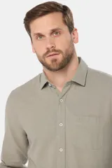 Camisa celeste de lino de manga larga con bolsillo en el pecho y botones personalizados.