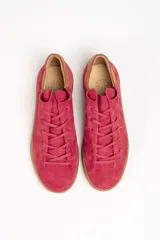 Zapatilla de cuero vacuno color rojo, con cordones al tono y suela de caucho color caramelo. Detalle de cuero vacuno color tostado en el talón.