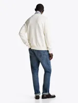 Sweater de punto texturizado color blanco, con cuello redondo, puños y bajo acanalados. Presenta un corte regular con hombros ligeramente caídos y el logo de la marca bordado en el pecho.