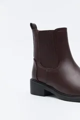 Bota tipo chelsea de caña baja, con laterales elastizados, tirador trasero y suela robusta.