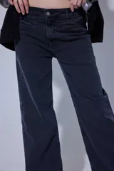 Pantalón de jean de tiro medio-alto con corte recto y ajuste relajado. Presenta un diseño clásico de cinco bolsillos con costuras reforzadas y cierre frontal con botón metálico.