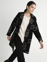 Tapado negro con estampado de texto en color blanco, cuello solapa y cierre frontal con un botón.