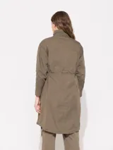 Parka verde militar de gabardina con mangas largas, jareta en cintura, ruedo y cuello con cordón interno al tono. Acceso frontal con broches dorados. Bolsillos delanteros y laterales.