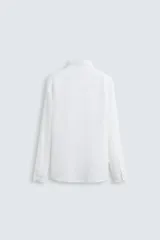 Camisa de corte regular fit confeccionada en tejido de lino, con cuello solapa, manga larga con puños abotonados y cierre frontal de botones.
