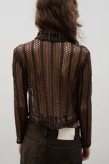Camisa de encaje con diseño floral, de corte recto y manga larga, con cierre frontal de botones clásicos y cuello camisero.