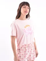 Conjunto de pijama compuesto por una remera de manga corta color rosa con estampa frontal y un short estampado con diseño pequeño y repetitivo.