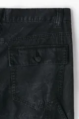 Pantalón estilo carpenter de corte holgado, confeccionado en tejido de algodón. Presenta tiro caído, bolsillos laterales de parche, trabilla funcional en una pierna y costuras reforzadas visibles sobre y debajo de las rodillas.