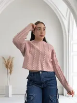 Sweater de punto trenzado color rosa, de corte cropped y mangas largas.