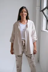 Campera tipo parka de color beige, con cierre frontal completo, capucha con cordones ajustables y mangas tres cuartos con detalle de trabilla y botón.