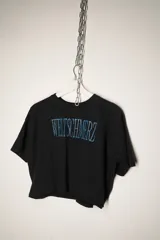 Remera negra de corte cropped con estampa frontal en color turquesa con la palabra Weltschmerz.