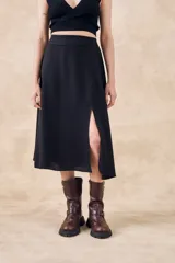 Falda midi negra de viscosa con cintura elastizada y abertura lateral.