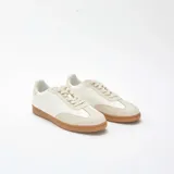 Zapatillas deportivas bajas de estilo retro, color blanco con detalles en tono crema y suela de goma color caramelo. Presentan cierre con cordones y puntera reforzada con diseño dentado.