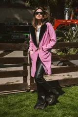 Tapado de paño de lana color rosa con cuello de piel sintética negra, largo hasta la rodilla, bolsillos delanteros y botón de guampa.