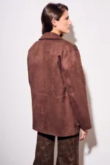 Campera estilo chaqueta marrón oscuro con cuello solapa, cierre frontal con botones oscuros y bolsillos de parche en la parte delantera.