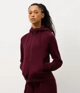 Campera deportiva de corte regular, color bordó, con cierre frontal de cremallera, capucha con cordón ajustable y bolsillos laterales. Confeccionada en tejido de algodón y poliéster.