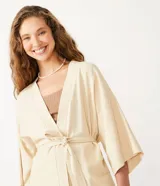Kimono color crema de tejido viscolino con mangas anchas y lazo en la cintura.