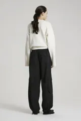 Pantalón tipo babucha de gabardina liviana color negro, con cintura elástica en espalda y tira regulable en delantero. Bolsillos en diagonal con bolsa pespunteada en delantero, bolsillos 3D plaqué en pierna delantera con tapa, tira regulable en botamanga y bolsillos plaqué con tapa en trasero.