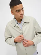 Campera aviadora color beige, de corte clásico, con cuello camisero, cierre frontal con cremallera, bolsillos laterales y puños elastizados.
